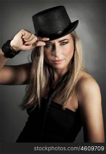 Portrait of sexy stylish attractive model wearing black hat and tie posing over gray background in the studio, luxury fashion look
