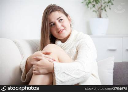 Portrait of sexy woman in sweater sitting in living room