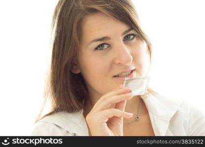 Portrait of sexy young brunette woman holding packed condom against white background