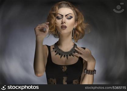portrait of sexy young girl with bizarre look, creative purple make-up and dark dress and accessories