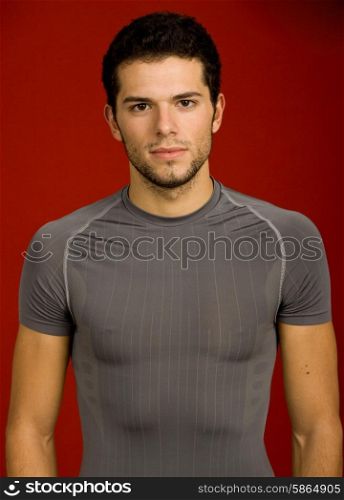 Portrait of sexy young man, against red background