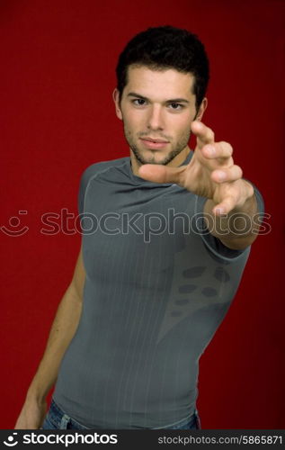 Portrait of sexy young man, against red background