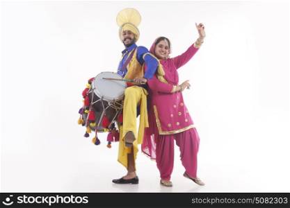 Portrait of Sikh couple doing bhangra dance