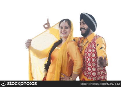 Portrait of Sikh couple doing bhangra dance