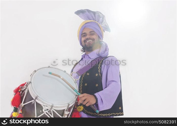 Portrait of Sikh man playing on drums