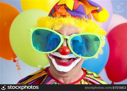 Portrait of silly clown in oversized sunglasses.