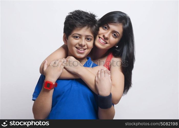 Portrait of Sister with arms around her brother looking at camera and smiling