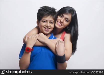 Portrait of Sister with arms around her brother looking at camera and smiling