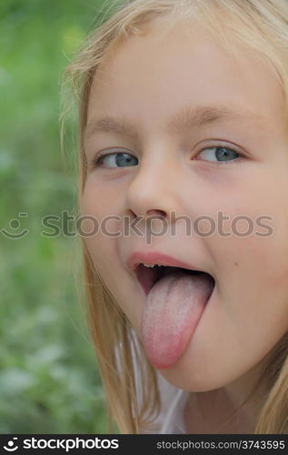 Portrait of small girl with put out tongue