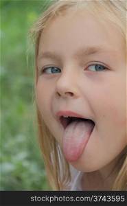 Portrait of small girl with put out tongue