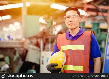 Portrait of smart engineer Asian Chinese happy labor worker handsome model in heavy industry  background.Hard hat off hand holding.