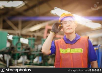Portrait of smart engineer Asian Chinese happy labor worker handsome model in heavy industry  background.hand at protection glasses.