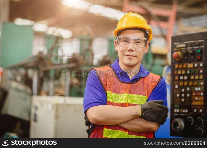 Portrait of smart engineer Asian Chinese happy labor worker handsome model in heavy industry  background.arm folded cross and smiling.