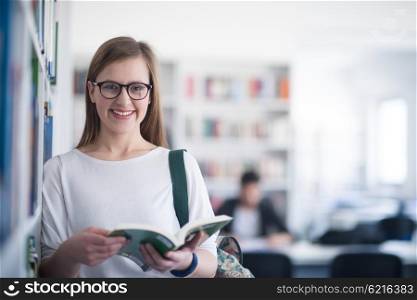 portrait of smart looking famale student girl in collage school library reading book
