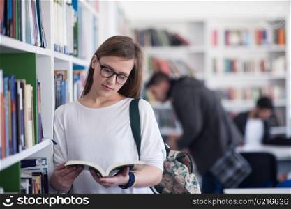portrait of smart looking famale student girl in collage school library reading book