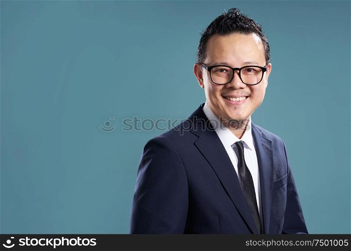 Portrait of smile asian businessman in suit . isolated on light blue background .