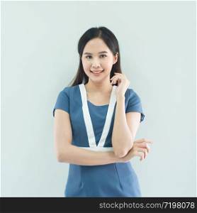 Portrait of smiling asian businesswoman standing with arms folded and looking at camera isolated over grey background