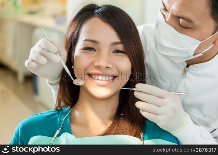 Portrait of smiling asian woman sitting at the dentist