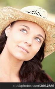 portrait of smiling attractive young woman wearing straw hat