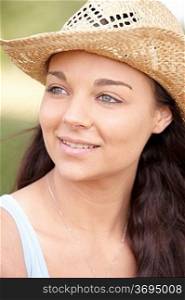 portrait of smiling attractive young woman wearing straw hat