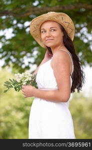 portrait of smiling attractive young woman wearing straw hat