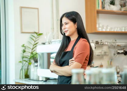 Portrait of smiling baristas with arms crossed at the coffee shop.