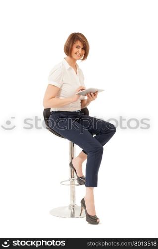 Portrait of smiling beautiful businesswoman sitting on chair, holding tablet. Isolated, studio shot.
