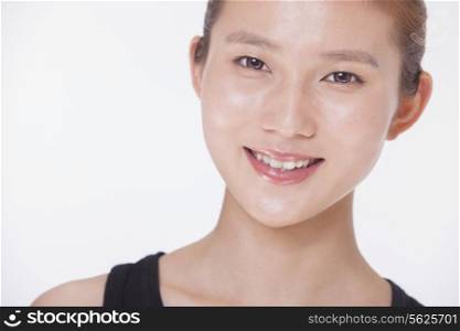 Portrait of smiling beautiful young woman in a black tank top, studio shot