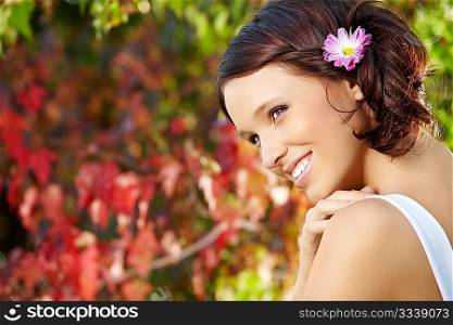 Portrait of smiling beauty against a blossoming garden