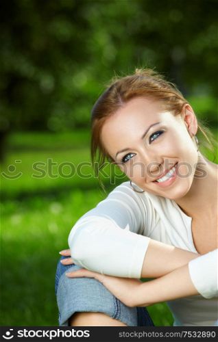 Portrait of smiling beauty against a summer garden