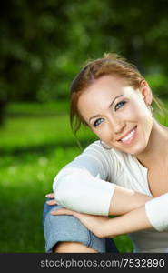 Portrait of smiling beauty against a summer garden