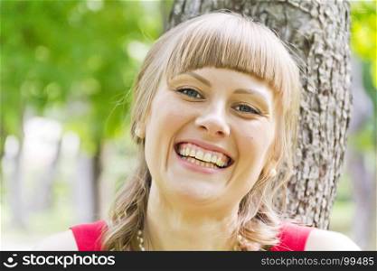 Portrait of smiling blond girl on green wood background