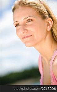 Portrait of smiling blond woman enjoy sunny summer day