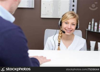 portrait of smiling blonde receptionist wearing headset