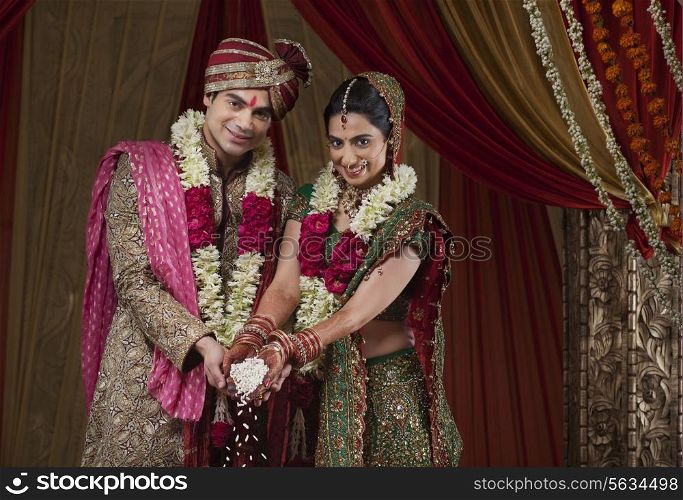 Portrait of smiling bride and bridegroom during traditional ceremony