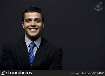 Portrait of smiling business man over black background