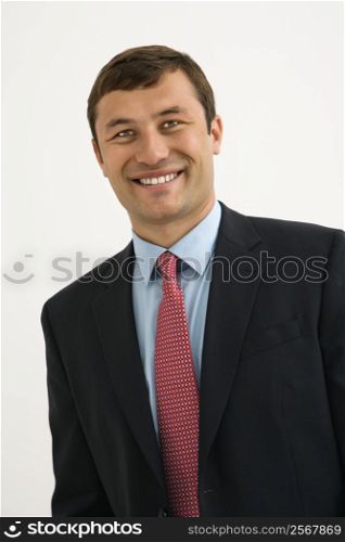 Portrait of smiling businessman against white background.