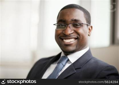 Portrait of smiling businessman in glasses, head and shoulders