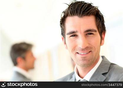 Portrait of smiling businessman standing in hall