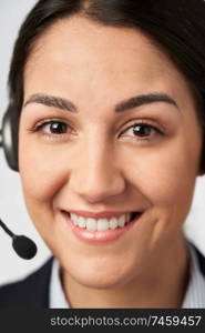 Portrait Of Smiling Businesswoman Wearing Telephone Headset In Customer Services Department                            