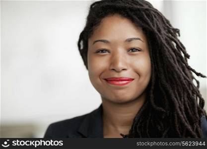 Portrait of smiling businesswoman with dreadlocks, head and shoulders