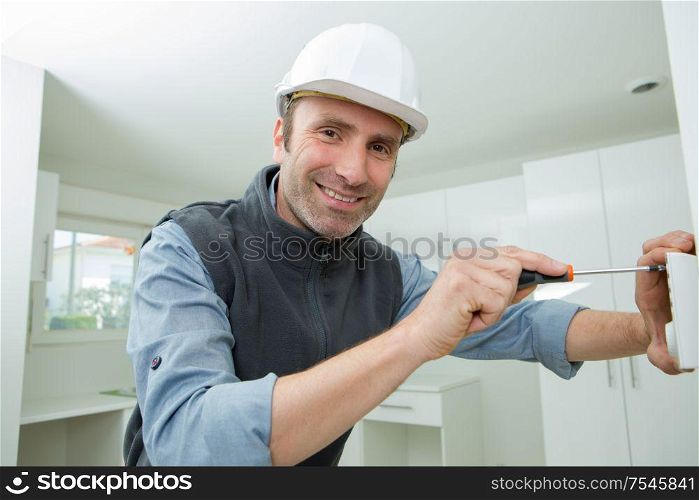 portrait of smiling carpenter install door