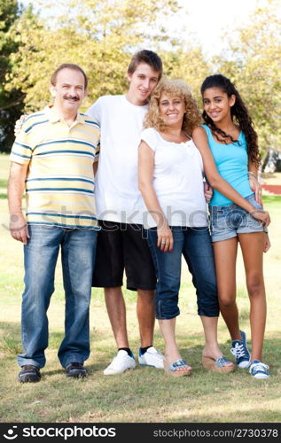 Portrait of smiling Caucasian family with a boy and girl posing along with parents outdoors.....