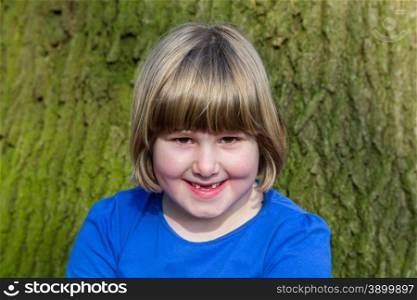 Portrait of smiling caucasian girl in front of oak trunk with bark