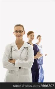 Portrait of smiling Caucasian medical healthcare workers in uniforms standing against white background.