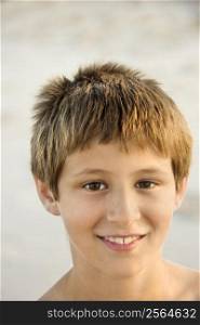 Portrait of smiling Caucasian pre-teen boy on beach.
