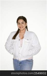 Portrait of smiling Caucasian teen girl with hands in coat pocket against white background.