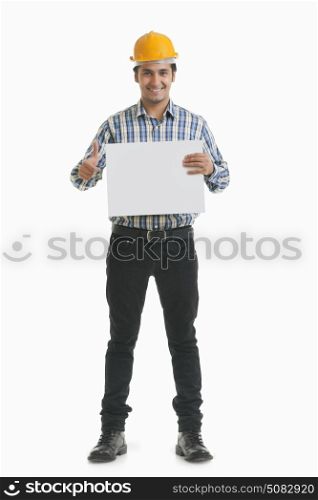 Portrait of smiling contractor holding placard gesturing thumbs up