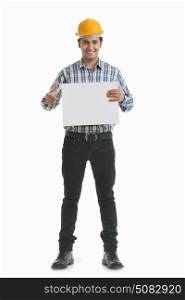 Portrait of smiling contractor holding placard gesturing thumbs up