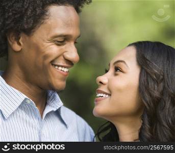 Portrait of smiling couple looking into eachother&acute;s eyes.